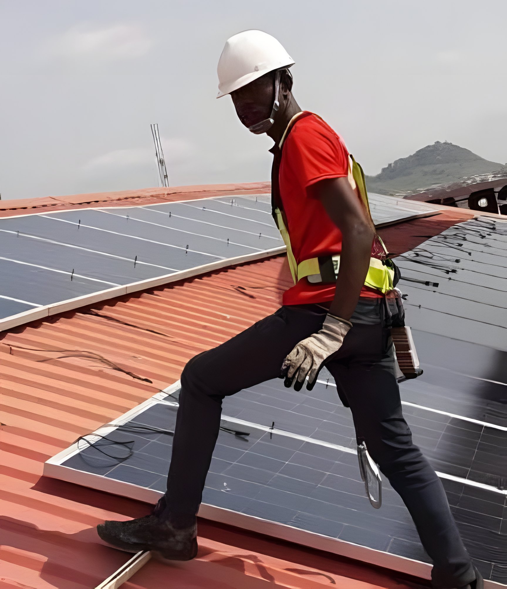 Technician fixing panels to a metal roof during a solar for factories installation